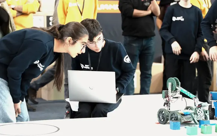A team checking their robot on a laptop before a run