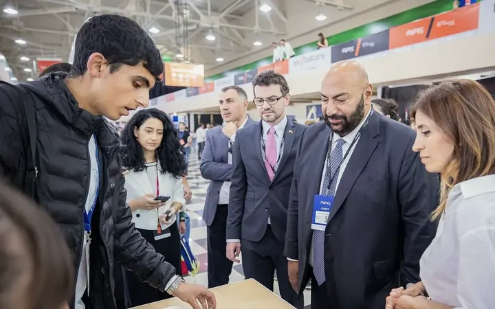 Guests at the Armath stand at DigiTec looking at a student project