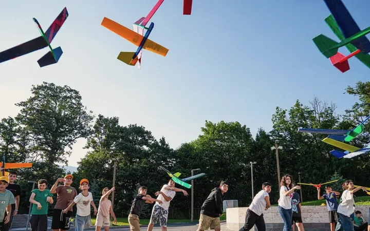 Paper planes flying over Techno Camp