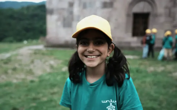 A smiling camper in a Techno Camp cap